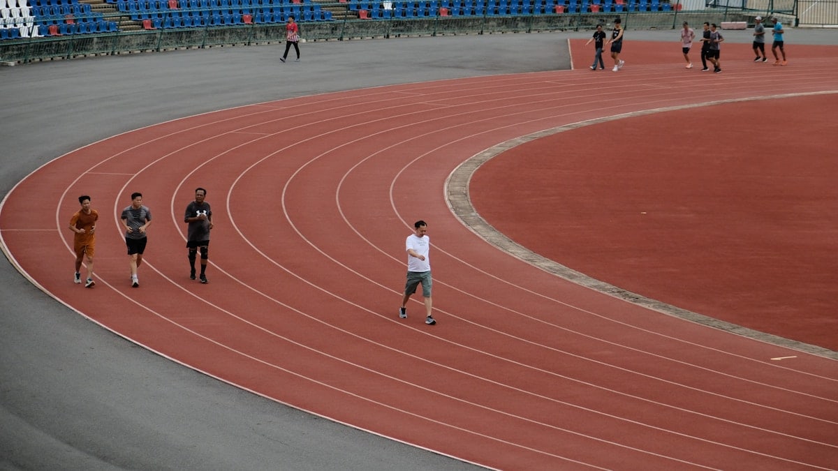 A group of people running around a track